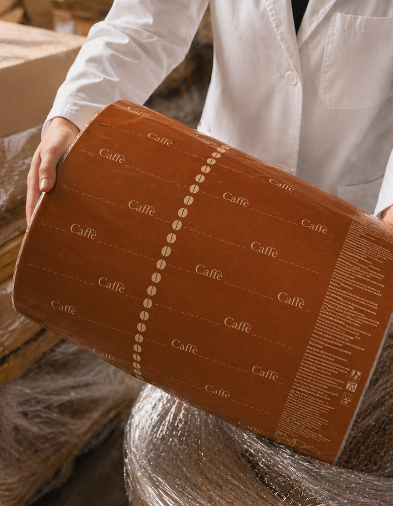 persona che tiene in mano una grande bobina di film flessibile per packaging